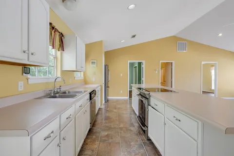 a large kitchen with a sink and cabinets