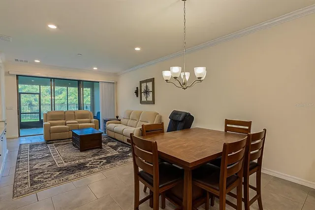 a view of a dining room with furniture a chandelier and wooden floor