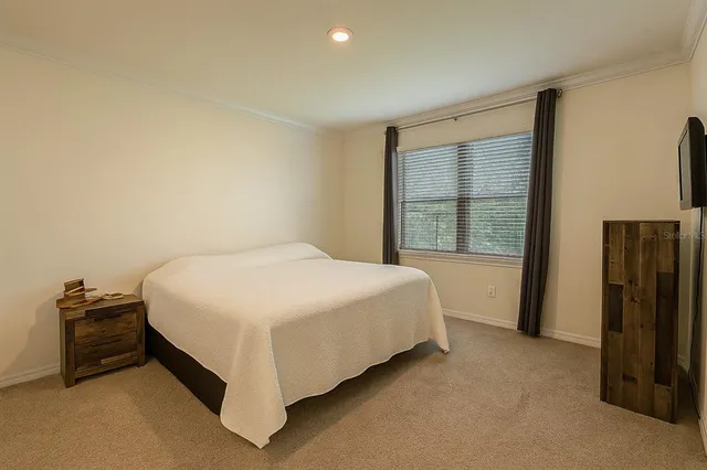 a spacious bedroom with a bed and a large window