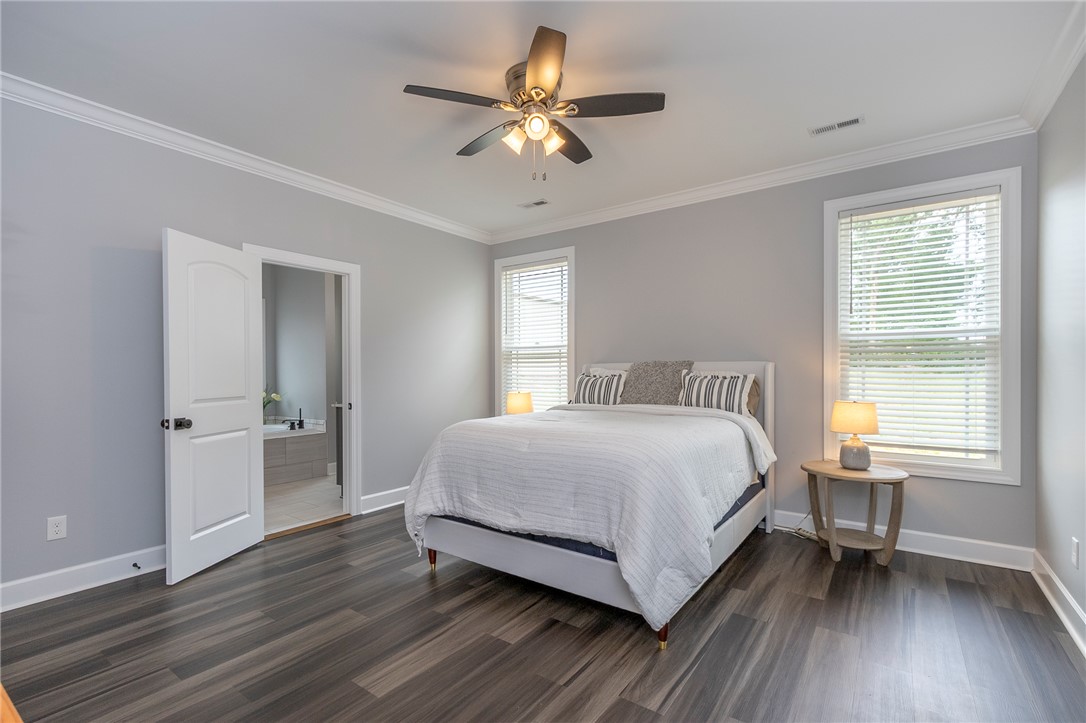 3080 McGee Road Iva, SC 29655 - Photo 28 of 49 Well-lit sleeping quarters with rich wood flooring and a modern ceiling fan for comfort.
