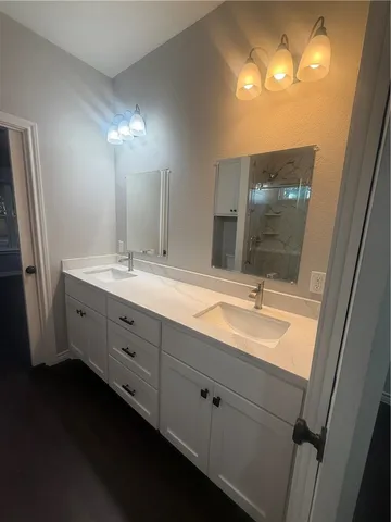 a bathroom with a double vanity sink and a mirror