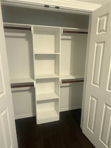 a view of walk in closet with empty racks