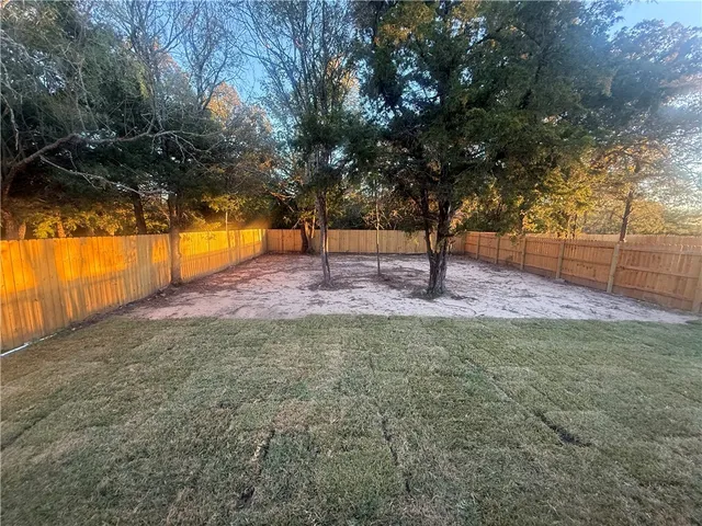 a view of yard with tree and a wooden fence