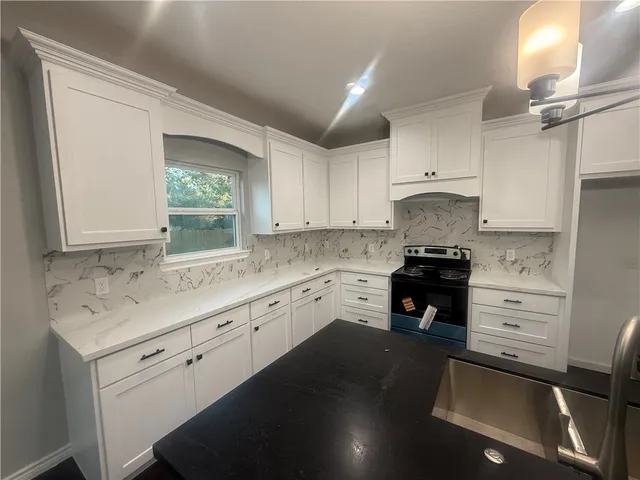 a kitchen with granite countertop a sink cabinets and window