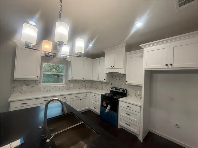 a kitchen with a sink cabinets and window