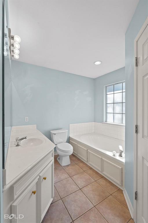 136 Scarborough Road Benton, LA 71006 - Photo 20 of 37 Bathroom featuring a built-in soaking tub with paneled surround, ceramic tile flooring, a white vanity with integrated sink, and a rectangular window with grid inserts