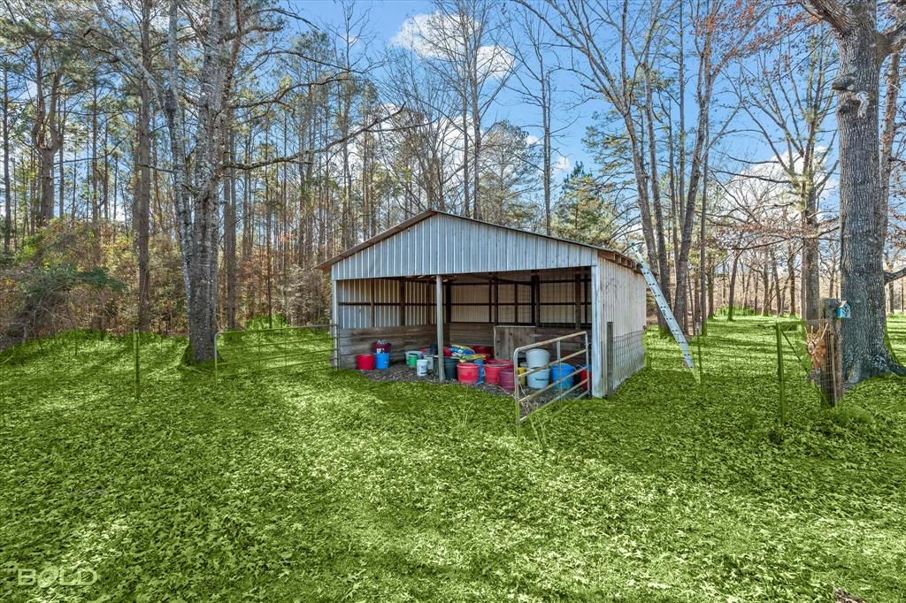 136 Scarborough Road Benton, LA 71006 - Photo 24 of 37 Metal-sided barn structure with an open-front design, featuring a sturdy metal roof and a partial fencing system