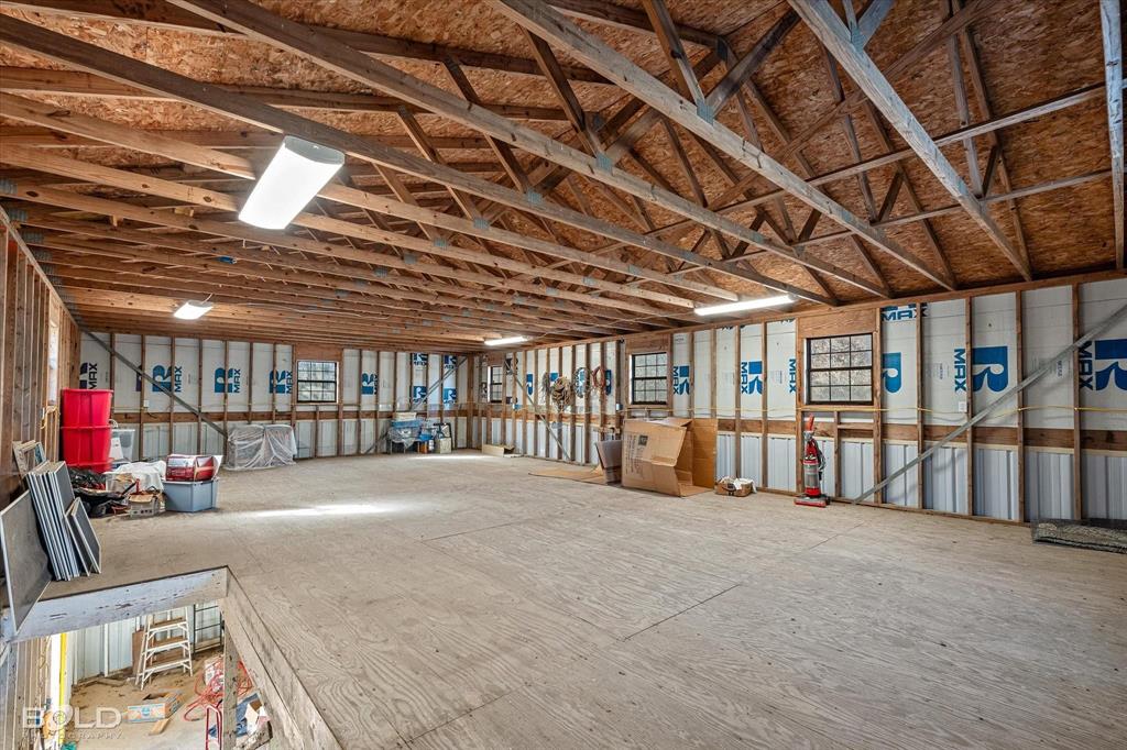136 Scarborough Road Benton, LA 71006 - Photo 26 of 37 Spacious upper level featuring exposed wood trusses, multiple windows, and fluorescent overhead lighting