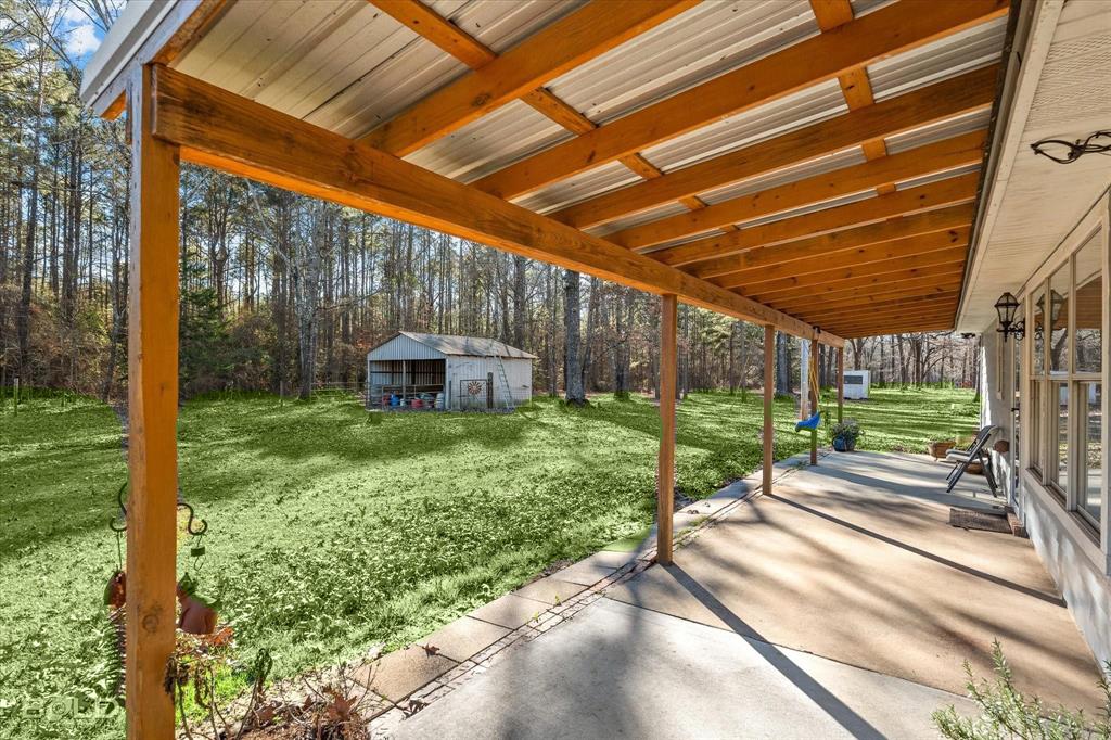 136 Scarborough Road Benton, LA 71006 - Photo 30 of 37 Expansive covered patio with a concrete surface and exposed wood beam ceiling