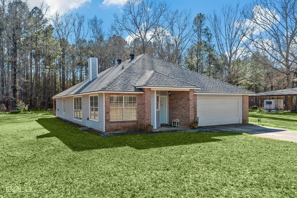136 Scarborough Road Benton, LA 71006 - Photo 35 of 37 Brick and siding exterior featuring a light blue front door, attached two-car garage, and a gabled roof