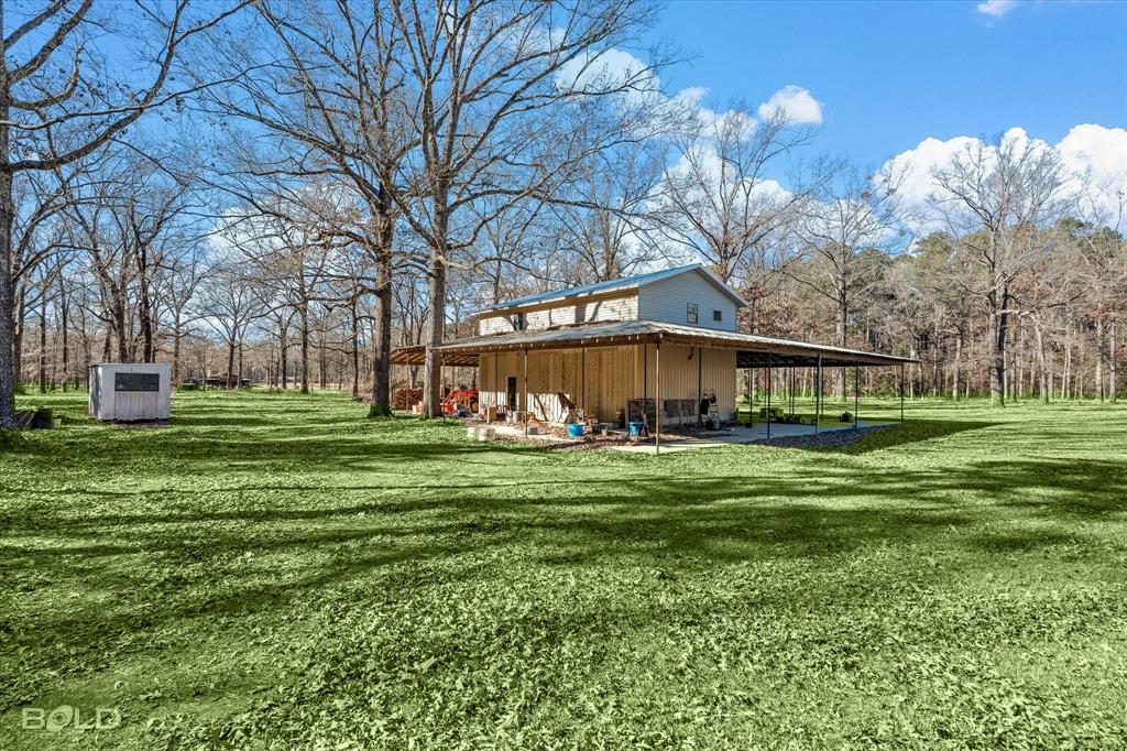 136 Scarborough Road Benton, LA 71006 - Photo 4 of 37 Two-story structure with a metal roof and a spacious, covered concrete patio extending along one side