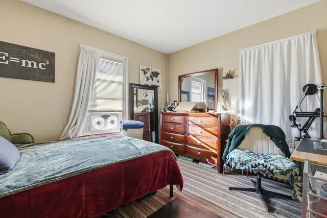 a bedroom with bed couch and window