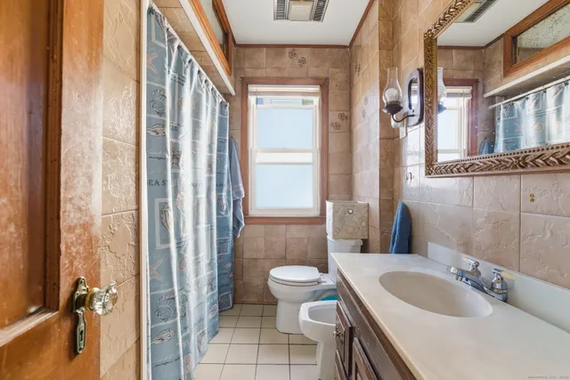 a bathroom with a sink toilet mirror and shower