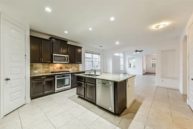 a kitchen with stainless steel appliances granite countertop a stove top oven and sink
