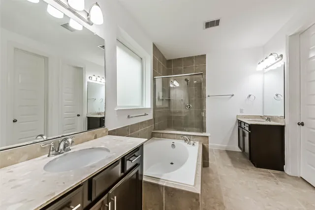 a bathroom with a granite countertop sink double vanity and a mirror