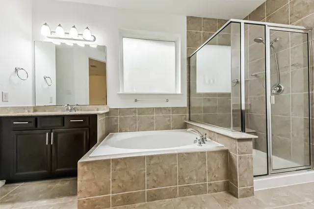 a spacious bathroom with a tub sink and mirror