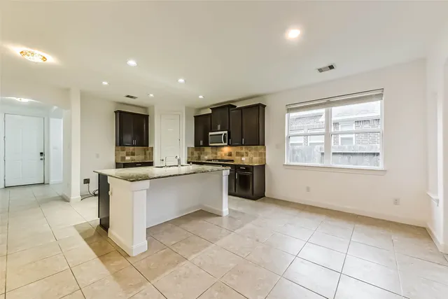 a kitchen with stainless steel appliances kitchen island granite countertop a sink and cabinets