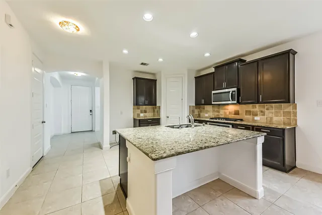 a kitchen with stainless steel appliances granite countertop a sink and stove
