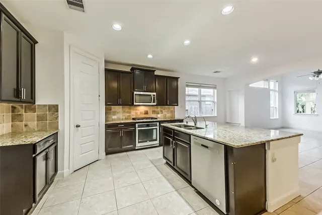 a kitchen with stainless steel appliances granite countertop a stove sink and cabinets