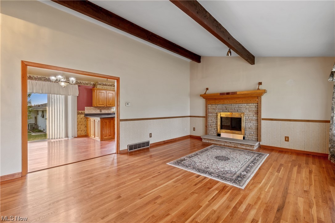 120 Lester Road New Franklin, OH 44319 - Photo 3 of 24 Hardwood floored living room featuring lofted ceiling with beams and a fireplace