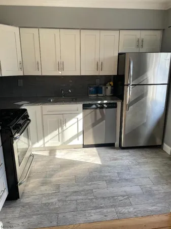 a kitchen with stainless steel appliances granite countertop a stove a refrigerator and a sink