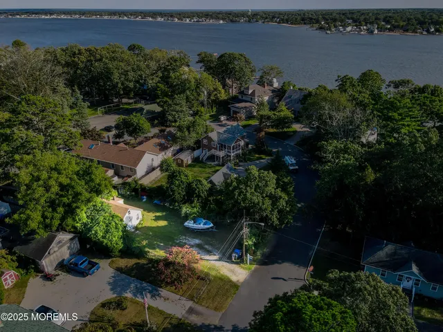 an aerial view of a house with a garden and lake view