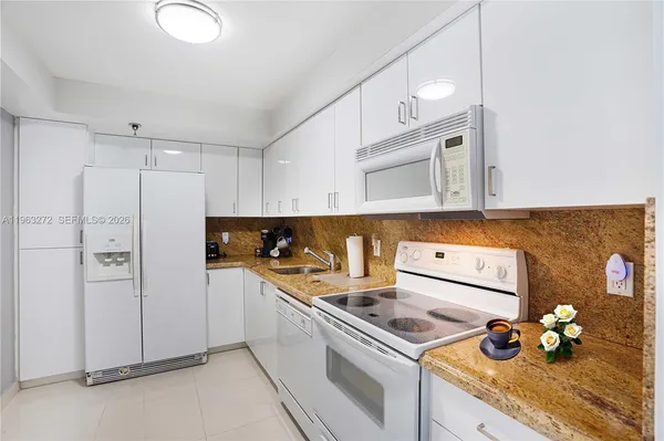 a kitchen with stainless steel appliances granite countertop a sink a stove and cabinets