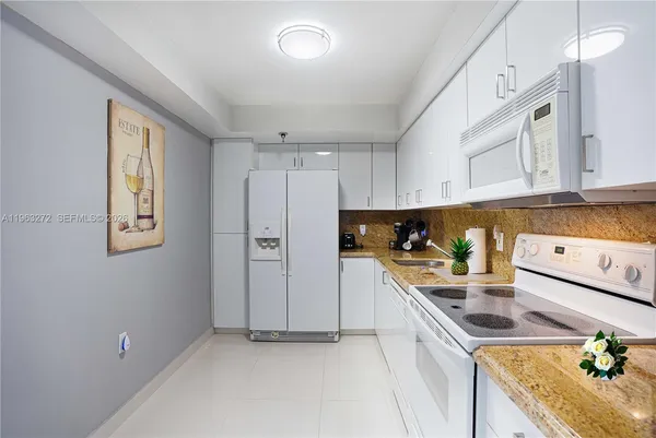 a kitchen with stainless steel appliances granite countertop a sink a stove a refrigerator a center island and cabinets