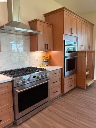a kitchen with stainless steel appliances a stove and a microwave