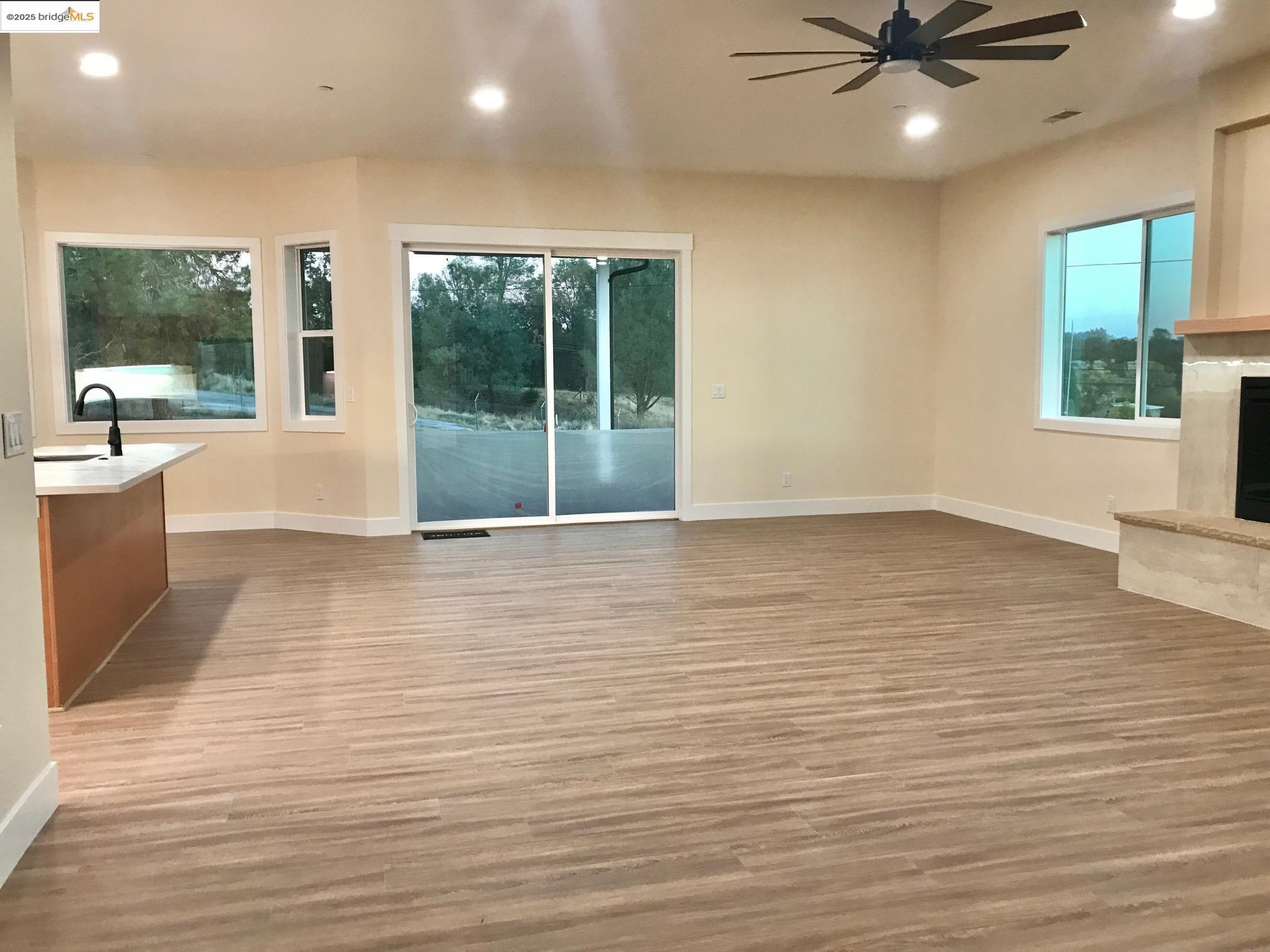 17500 Harvard Mine Road Jamestown, CA 95327 - Photo 19 of 37 Unfurnished living room featuring recessed lighting, light wood-style flooring, a high end fireplace, and ceiling fan