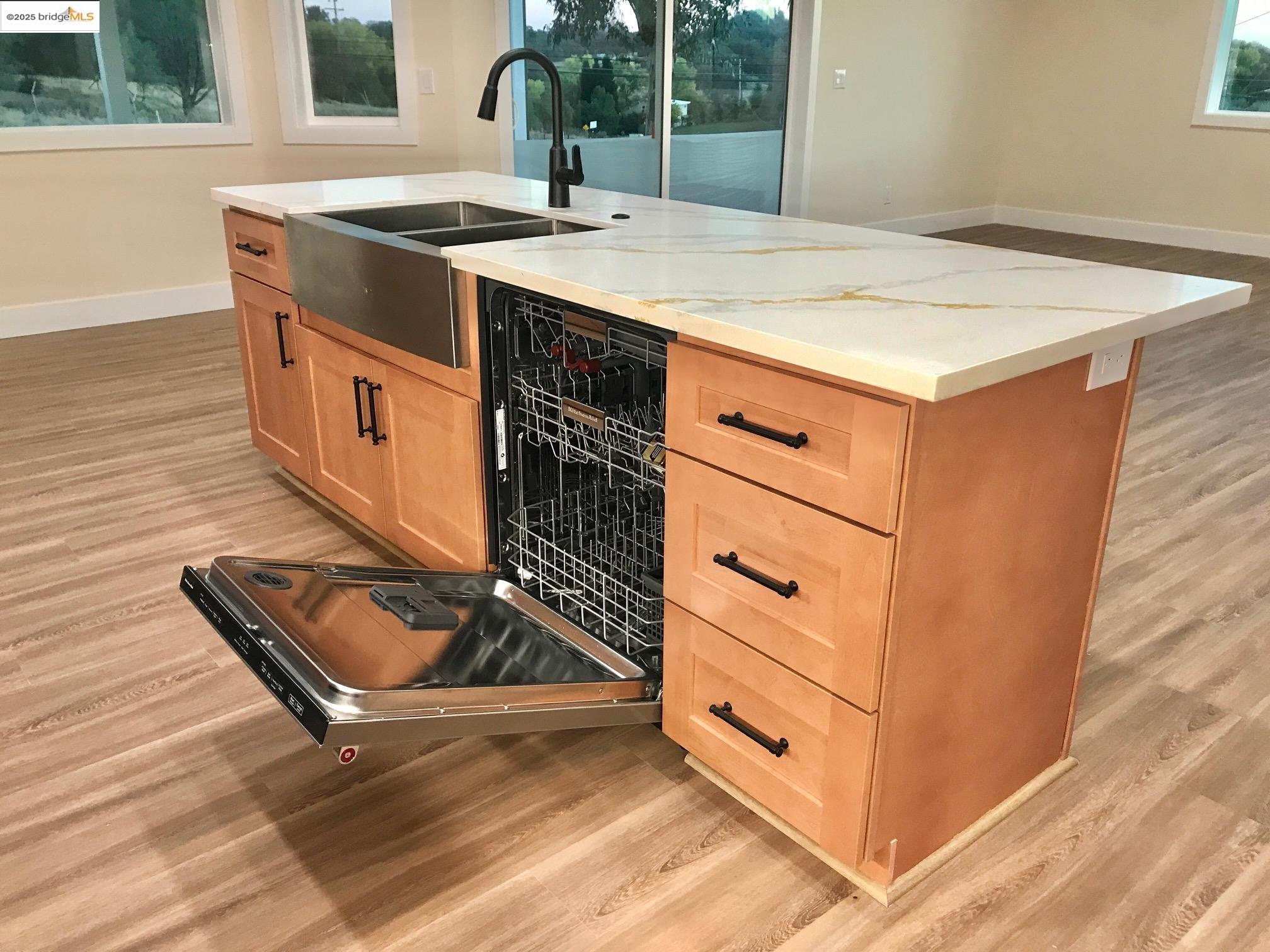17500 Harvard Mine Road Jamestown, CA 95327 - Photo 6 of 28 Kitchen featuring dishwashing machine, light wood-type flooring, a center island with sink, and light brown cabinetry
