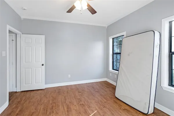 an empty room with wooden floor and windows