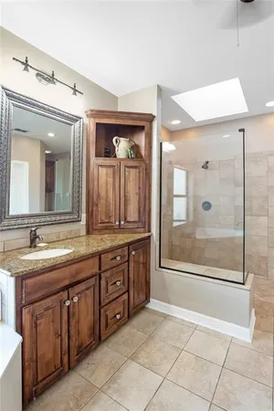 a spacious bathroom with a granite countertop sink mirror and bathtub