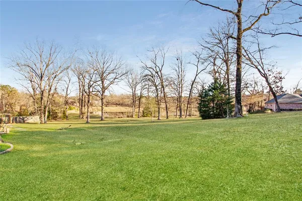 a big yard with trees in front of it