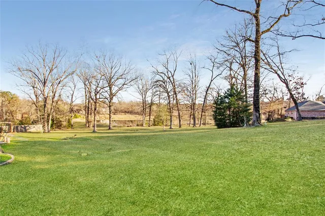 a big yard with trees in front of it