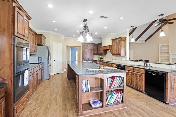 a kitchen with stainless steel appliances granite countertop a sink stove and wooden floor