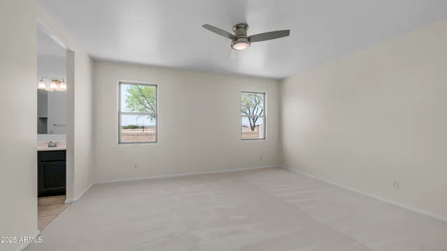 an empty room with windows and fan