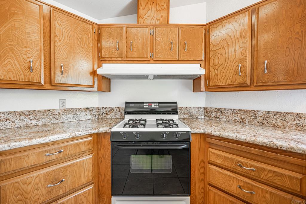 4650 Dulin Road, Unit 178 Fallbrook, CA 92003 - Photo 15 of 56 a kitchen with granite countertop cabinets stainless steel appliances and wooden floor