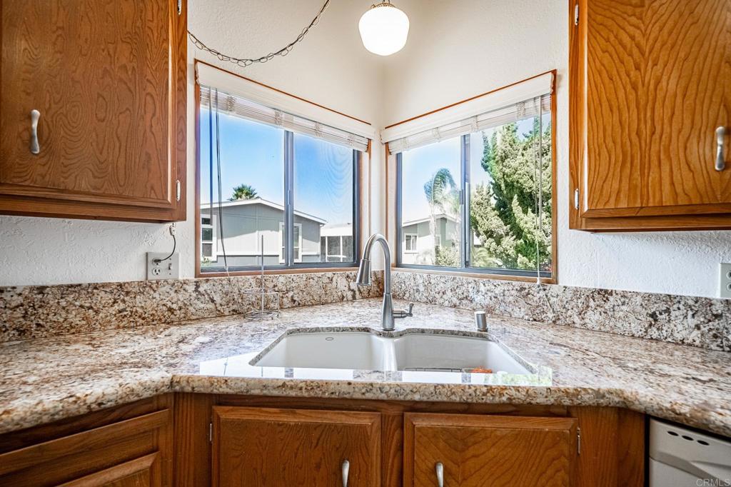 4650 Dulin Road, Unit 178 Fallbrook, CA 92003 - Photo 17 of 56 a kitchen with granite countertop a sink window and cabinets