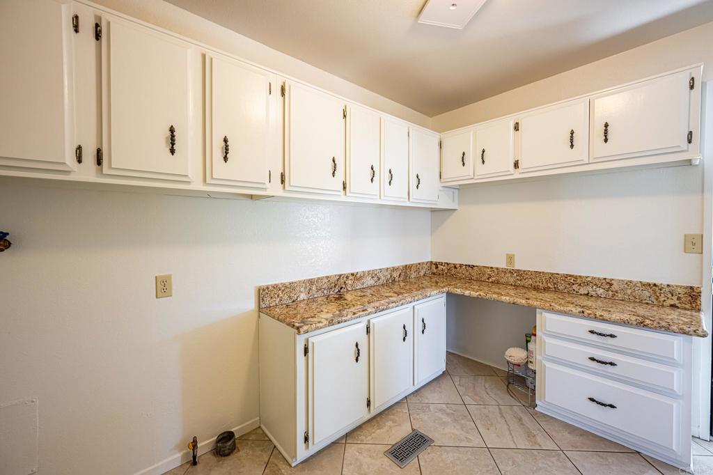4650 Dulin Road, Unit 178 Fallbrook, CA 92003 - Photo 18 of 56 a kitchen with granite countertop white cabinets and white appliances