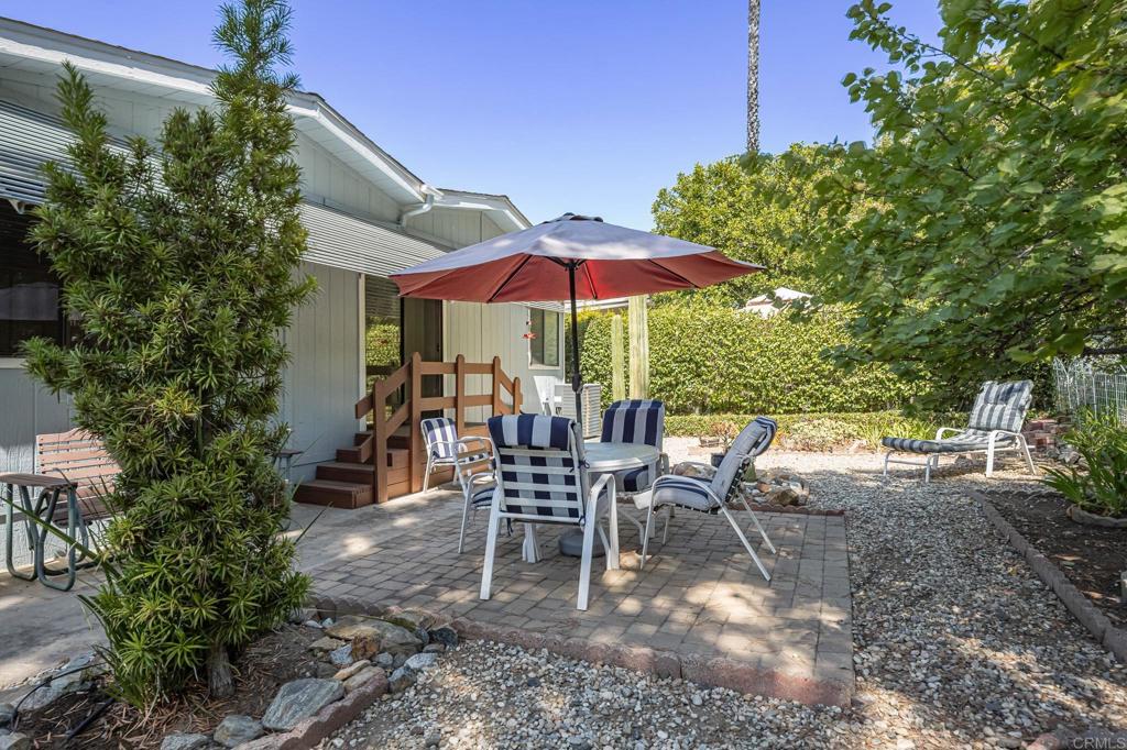 4650 Dulin Road, Unit 178 Fallbrook, CA 92003 - Photo 32 of 56 a view of a patio with chairs and table under an umbrella