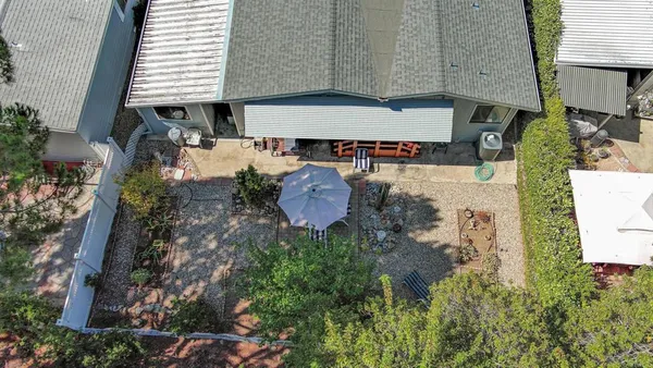 an aerial view of residential houses with outdoor space and trees