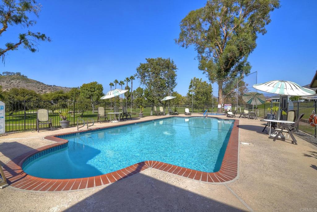 4650 Dulin Road, Unit 178 Fallbrook, CA 92003 - Photo 49 of 56 a view of a swimming pool with a table and chairs under an umbrella