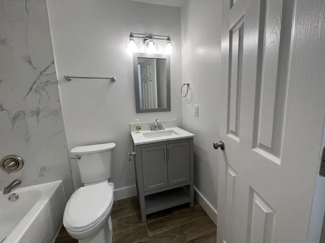 a bathroom with a toilet sink and mirror