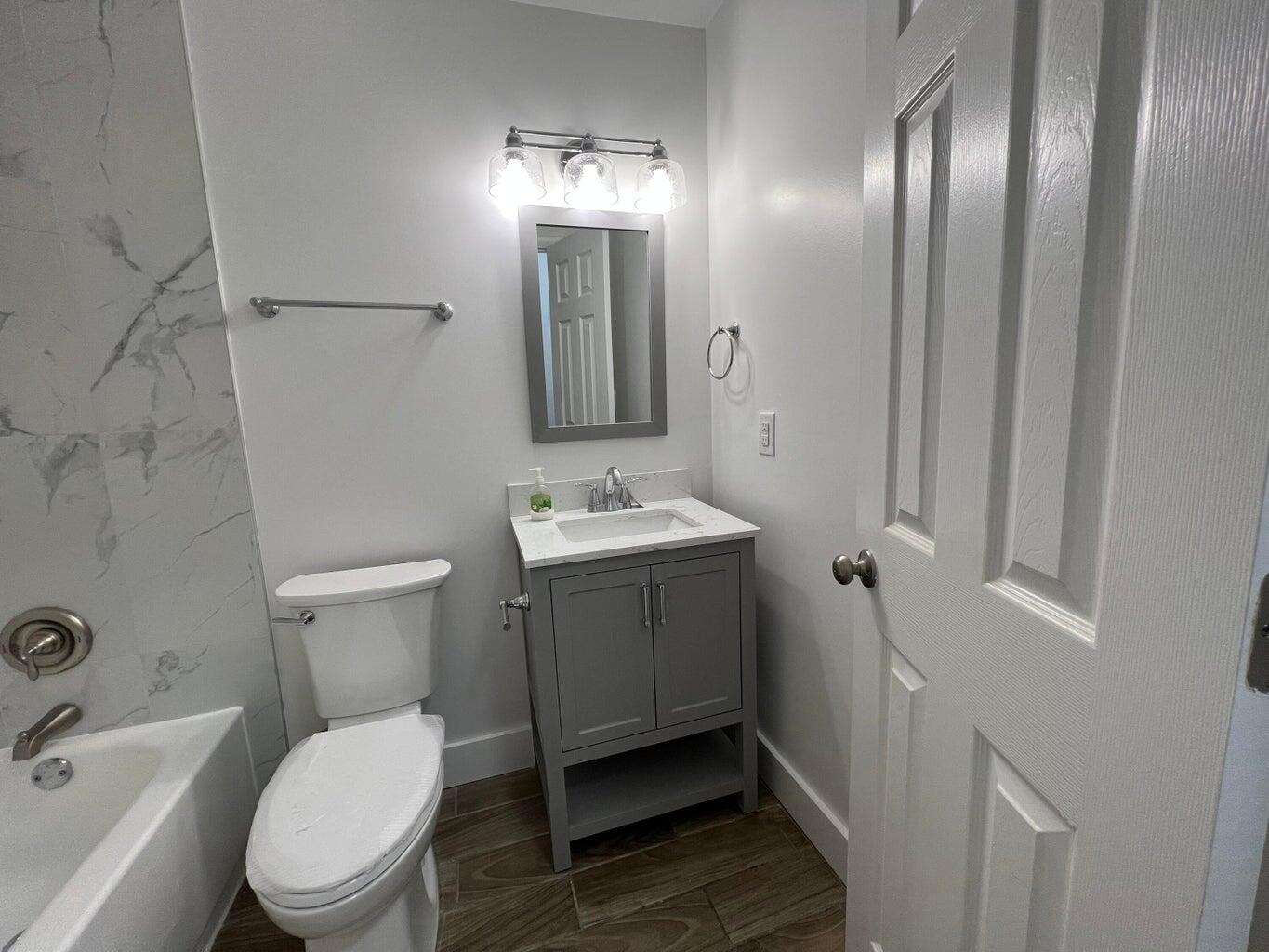 1050 West 7th Street Riviera Beach, FL 33404 - Photo 11 of 15 a bathroom with a toilet sink and mirror
