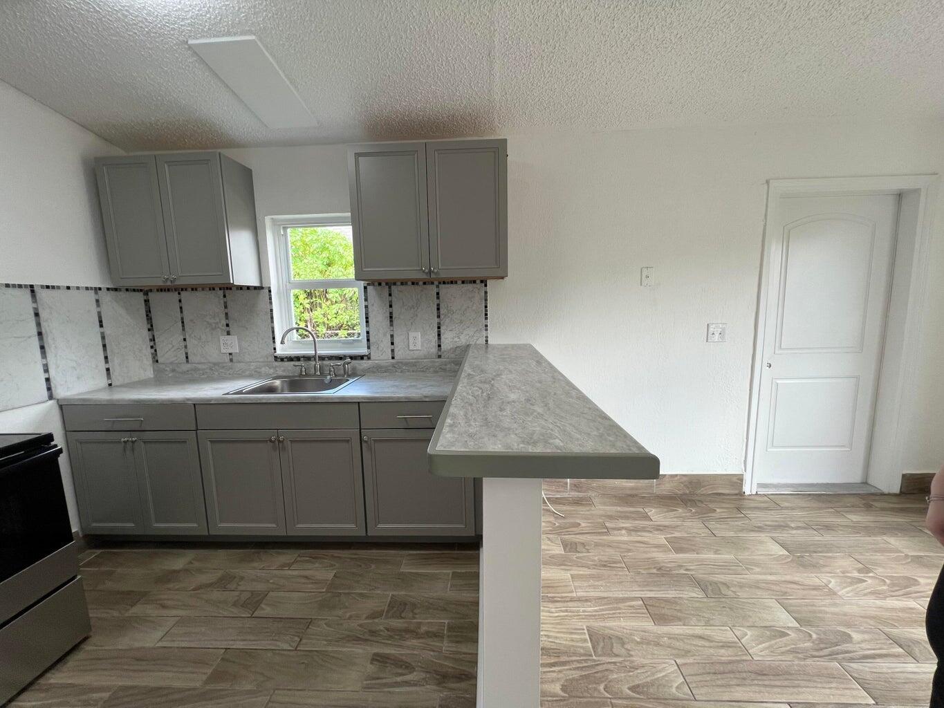 1050 West 7th Street Riviera Beach, FL 33404 - Photo 15 of 15 a kitchen with cabinets appliances and a window