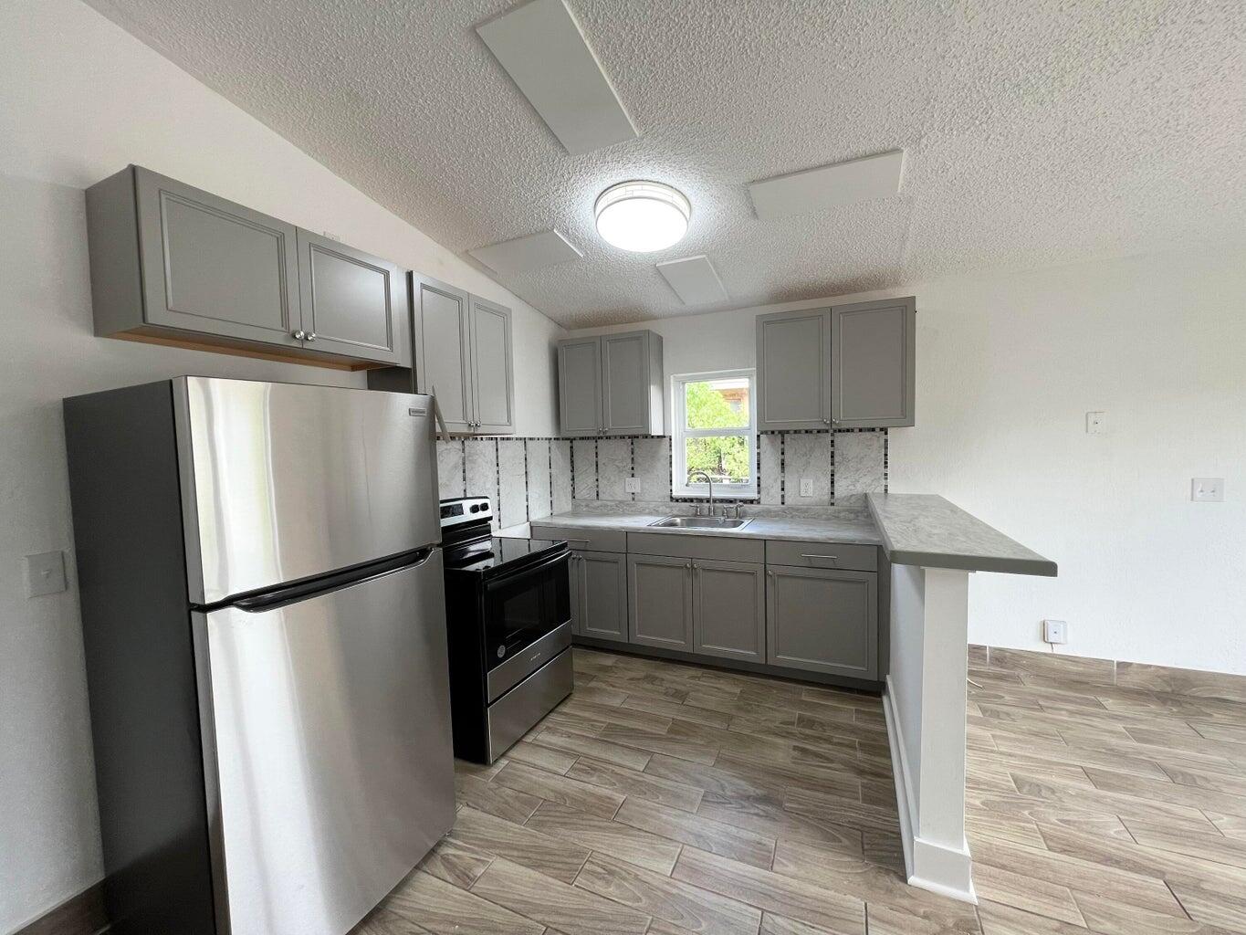 1050 West 7th Street Riviera Beach, FL 33404 - Photo 4 of 15 a kitchen with a refrigerator and a sink