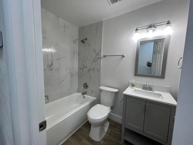 a bathroom with a toilet sink and mirror
