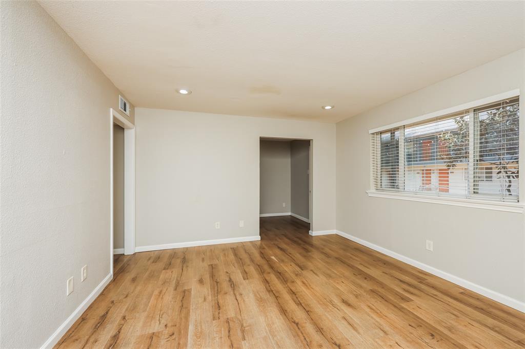 4618 Reiger Avenue, Unit 104 Dallas, TX 75246 - Photo 8 of 19 a view of an empty room with wooden floor and a window