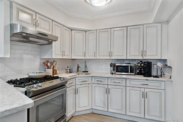 a kitchen with white cabinets and appliances
